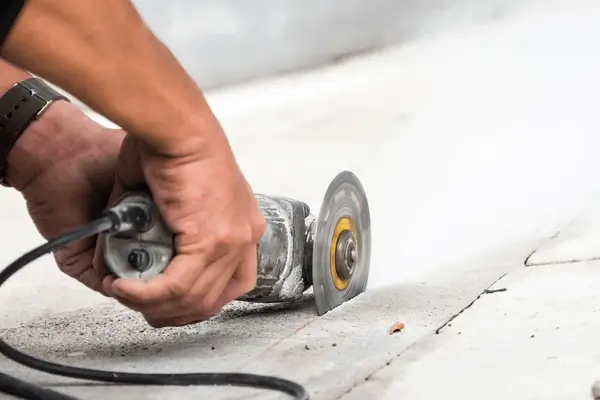 Hand-held grinder in use on concrete surface, Concrete Grinding Auckland.