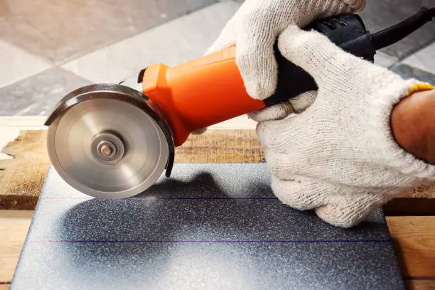 Worker cutting material with precision tool, Concrete Grinding Auckland.
